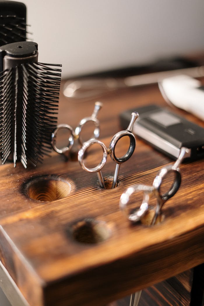 our-services-1 Close-up of professional hairdressing equipment on a wooden salon table, ready for use.