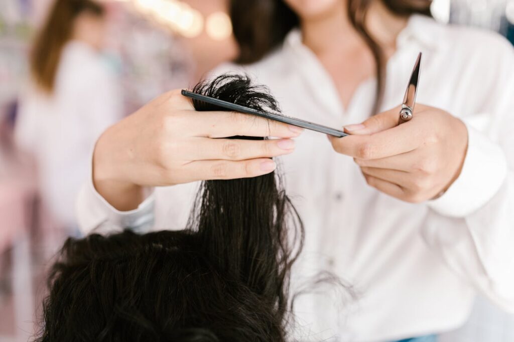 pexels photo 7755222 Professional hairdresser cutting hair with scissors and comb in a salon setting.